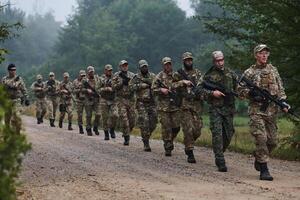 An elite military unit, led by a major, confidently parades through dense forest, showcasing precision, discipline, and readiness for high-risk operations photo
