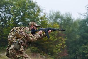An elite soldier, camouflaged and stealthily navigating through dangerous woodland terrain, executes a covert mission in a secluded forest area photo