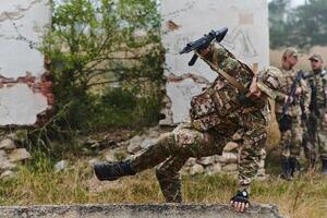 A highly trained elite military unit, clad in camouflage, skillfully navigates through perilous forest terrain, overcoming obstacles and executing a precise and covert mission photo