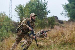 Elite soldiers stealthily maneuver through the dense forest, camouflaged in specialized gear, as they embark on a covert and strategic military mission photo