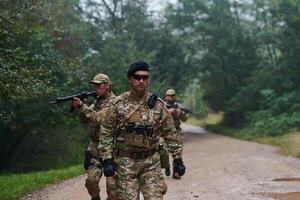 A disciplined and specialized military unit, donned in camouflage, strategically patrolling and maintaining control in a high-stakes environment, showcasing their precision, unity, and readiness for photo