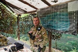 The esteemed leader of an elite military unit, strategic brilliance unfolds as he meticulously devises tactical plans for the upcoming military operation, surrounded by cutting-edge technology and a photo