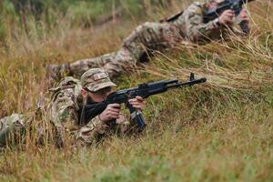 Elite soldiers stealthily maneuver through the dense forest, camouflaged in specialized gear, as they embark on a covert and strategic military mission photo