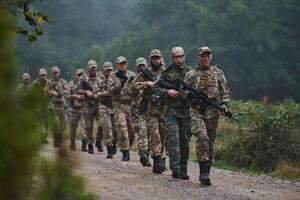 An elite military unit, led by a major, confidently parades through dense forest, showcasing precision, discipline, and readiness for high-risk operations photo