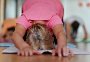 Senior Woman Practicing Back Stretches in a Sunlit Space for Optimal Health and Well Being photo