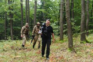 A videographer captures the intensity of a perilous military operation, documenting soldiers in action amidst the dense forest, showcasing the hazardous conditions and tactical maneuvers undertaken by photo
