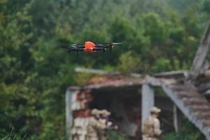 Elite military unit, equipped with state-of-the-art technology including a drone, strategically navigates and surveys dangerous wooded terrain, showcasing their precision, cooperation, and specialized photo