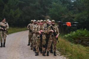 An elite military unit, led by a major, confidently parades through dense forest, showcasing precision, discipline, and readiness for high-risk operations photo