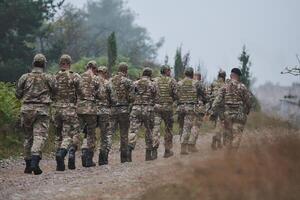 An elite military unit, led by a major, confidently parades through dense forest, showcasing precision, discipline, and readiness for high-risk operations photo