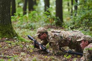 Elite soldiers stealthily maneuver through the dense forest, camouflaged in specialized gear, as they embark on a covert and strategic military mission photo