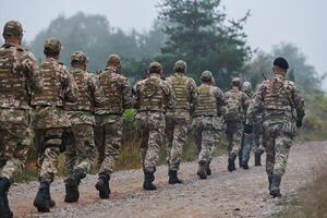 An elite military unit, led by a major, confidently parades through dense forest, showcasing precision, discipline, and readiness for high-risk operations photo