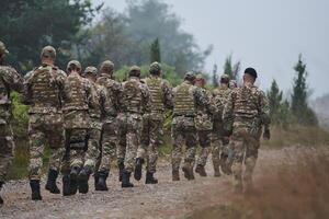 An elite military unit, led by a major, confidently parades through dense forest, showcasing precision, discipline, and readiness for high-risk operations photo