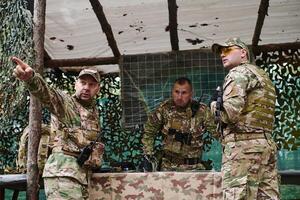 A highly trained military unit strategizes and organizes a tactical mission while studying a military map during a briefing session photo