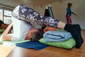 Senior Woman Practicing Back Stretches in a Sunlit Space for Optimal Health and Well Being photo
