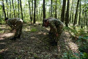 A dedicated group of soldiers engages in Islamic prayer amidst the challenging and perilous conditions of a military operation in dense forested areas photo