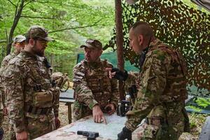 A highly trained military unit strategizes and organizes a tactical mission while studying a military map during a briefing session photo