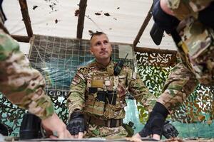 A highly trained military unit strategizes and organizes a tactical mission while studying a military map during a briefing session photo