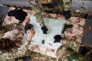 A highly trained military unit strategizes and organizes a tactical mission while studying a military map during a briefing session photo