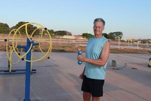 Older Man doing External Shoulder Rotation exercise with light weights for should pain photo