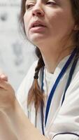 Vertical Physician meets with a patient to discuss medical results in a cabinet, using advanced diagnostic equipment to interpret x ray scans, demonstrating a professional healthcare approach. Camera A. video