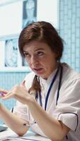 Vertical Physician meets with a patient to discuss medical results in a cabinet, using advanced diagnostic equipment to interpret x ray scans, demonstrating a professional healthcare approach. Camera B. video