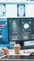 Vertical Doctor reading x ray imaging for a diagnostic report at consultation, discussing with a patient about medicine. Physician examining lab test results and analysis, health insurance. Camera A. video
