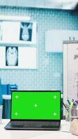 Vertical Doctor consulting a male patient in medical facility next to green screen, using modern technology for scan interpretation and diagnostics. Medic gives professional advice based on illness. Camera B. video