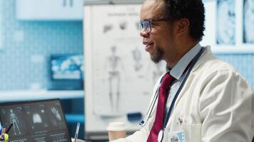 Doctor and patient discussing diagnostic results in a modern medical office, showcasing advanced healthcare technology using a screen displaying x rays and MRI scans. Care management. Camera A. video