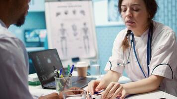 Physician measuring the oxygen saturation and pulse rate using an oximeter during check up visit, consulting her patient with modern medical equipment. Vital signs measurement. Camera B. video