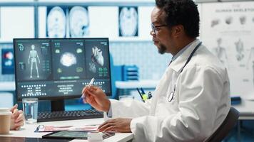 Medical expert discussing about diagnostics treatment with patient in cabinet, reviewing the test analysis reports during a consultation. Medic specialist supporting woman with illness. Camera A. video