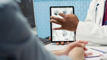 General practitioner pointing at the medical illustration to explain diagnosis to woman, discussing about x ray test analysis and looking at healthcare results. Checkup visit. Camera A. video