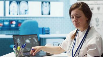 Medical expert discusses test results with a patient in a healthcare setting, utilizing diagnostic tools and computer technology for accurate medical analysis and consultation. Camera A. video