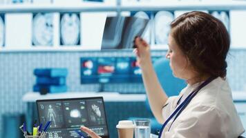 Medical staff reviewing diagnostic reports and results for a patient, focusing on x ray imaging and scan interpretation. Modern medical examination and patient diagnosis at clinic. Camera A. video