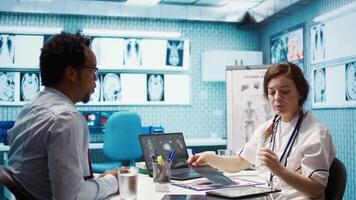 Medical expert discusses test results with a patient in a healthcare setting, utilizing diagnostic tools and computer technology for accurate medical analysis and consultation. Camera B. video