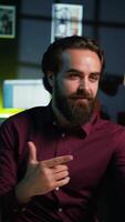 Vertical Expressive man using smartphone on selfie stick to shoot , doing frantic gesturing. Animated influencer making hectic hand movements while filming vlog with phone in studio, camera B video