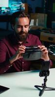 Vertical Media star in neon lit studio presents VR goggles from brand sponsoring , closely analyzing features. Influencer reviewing virtual reality headset for tech enthusiasts watching, camera B video
