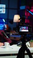 Vertical Content creator hosting online show in rgb lights studio, shooting vlog using professional gear. Vlogger presenting informations during streaming service broadcast filmed with camera, camera B video