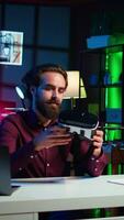 Vertical Close up shot of futuristic VR goggles held by man reviewing them for viewers. Internet star filming technology channel vlog for gadget enthusiasts, showcasing virtual reality headset, camera B video