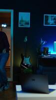 Vertical Content creator entering home studio, doing cool hand gesturing towards camera during live broadcast on online streaming platforms. Entertainer pointing fingers, captivating audience, camera B video