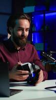vertical foco em Smartphone em anexo para tripé usava de conectados Estrela dentro embaçado fundo discutindo com espectadores. Móvel telefone usava de influenciador para registro social meios de comunicação , Câmera b fechar acima video