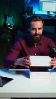 Vertical Tech guru using professional camera to film technology review of new cellphone, doing unboxing . Content creator showing phone box to subscribers, recording with high tech gear, camera B video