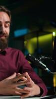 vertical asmr artista usando qualidade microfone e Smartphone em tripé dentro estúdio para Faz anti estresse , sussurrando formigamento sons. homem usando microfone e Móvel telefone para filme dormir induzindo contente, Câmera b video