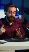 Vertical Artist filming DJ mixing tutorial, showing examples of sampling on sound controller to viewers. Viral online star showing modern musical equipment to subscribers in home studio, camera A video