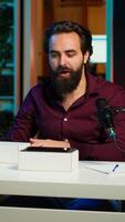 Vertical Tech influencer filming technology review of newly released smartphone, unboxing it and presenting specifications to audience. blogger showing phone to subscribers, camera A video