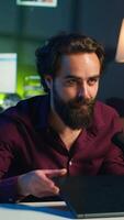 Vertical Influencer in studio endorsing laptop from brand sponsoring , talking in microphone. Content creator does influencer marketing by promoting notebook, recording with high tech mic, camera A video