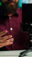 vertical asmr conteúdo O Criador usando qualidade microfone e celular em tripé para Faz anti estresse , usando sussurrando voz, fechar acima. homem usando profissional microfone para induzir sonolência para espectadores, Câmera uma video