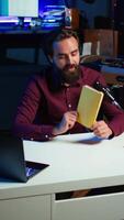 Vertical Online show host reading and recommending best reviewed books of the year. Content creator in studio doing novel summaries for interested readers, speaking in professional mic, camera B video