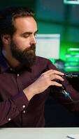 Vertical Portrait of upbeat content creator hosting online show in rgb lights studio, shooting vlog using professional microphone. Cheerful vlogger doing streaming service broadcast, camera A video