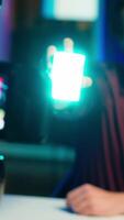 Vertical Tech guru filming technology review of mini led lights, offering feedback, close up shot. Friendly online star showing filming equipment to subscribers, talking in mic, camera A video