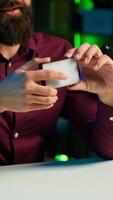 Vertical Reviewer discussing with viewers about mini led lights during live broadcast on internet, close up. Influencer chatting with fans during stream, filming RGB lighting device in studio, camera A video